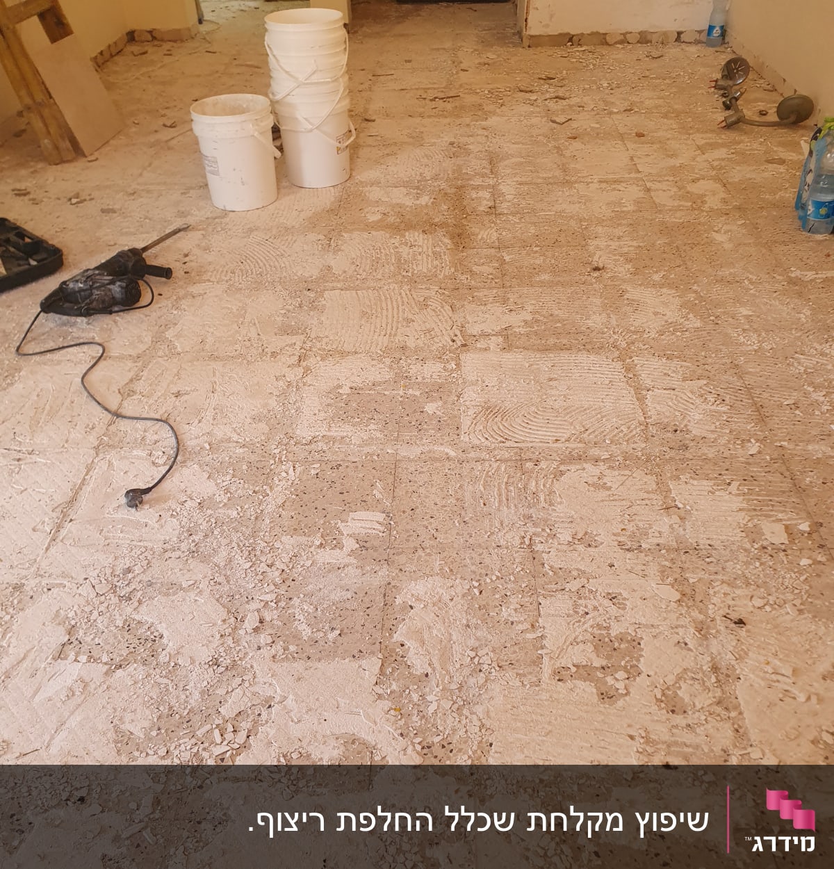 רצפה מפורקת עם דליים וכלי עבודה לשיפוץ